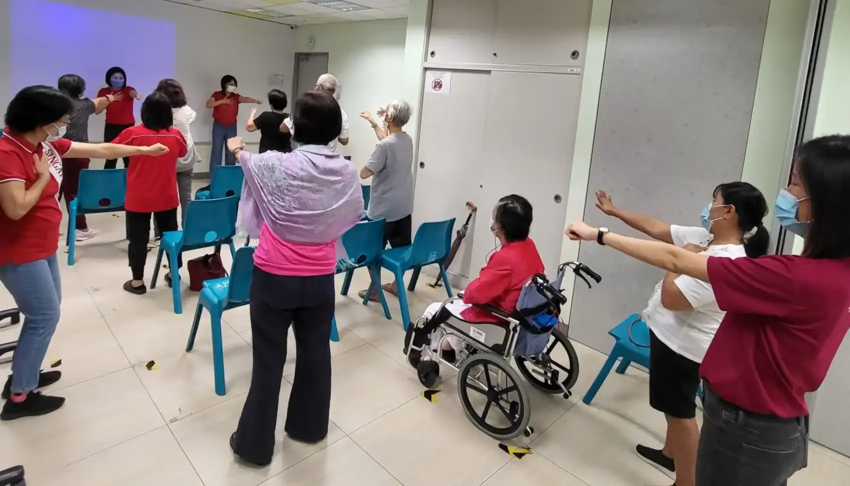 Seniors laughing and clapping during Laughter Yoga breathing exercises