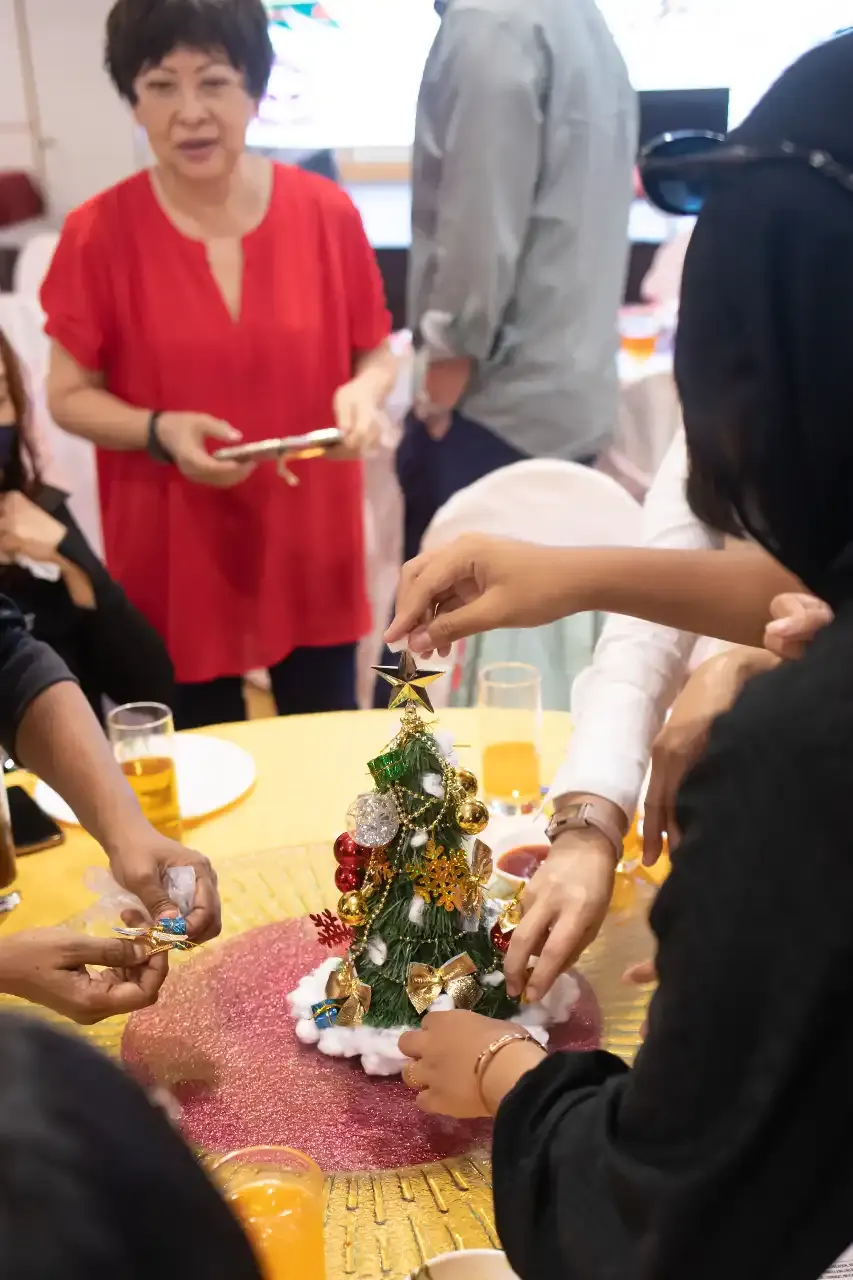 Residents decorating small Christmas trees at their tables