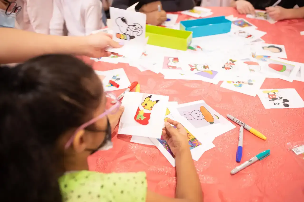 Children colouring and creating shrinky dink keychains at the art booth