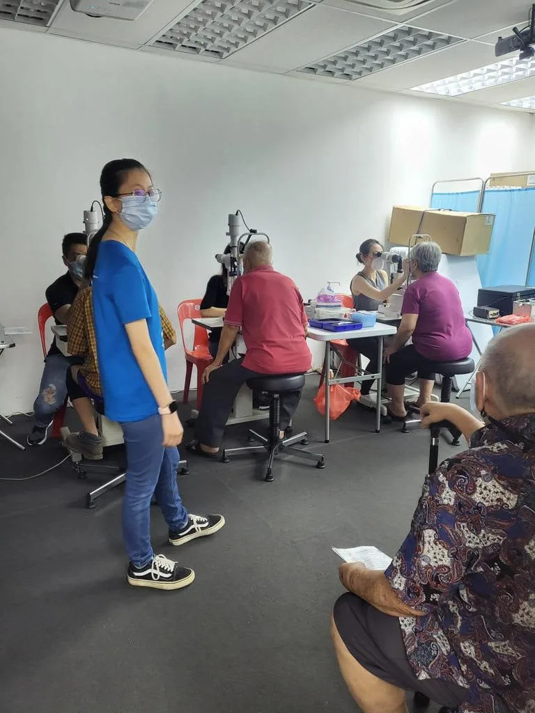 Dr Allan Fong examining a senior resident's eyes using SWA's eye examination equipment