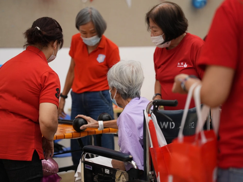 Volunteers assisting residents with National Day themed games