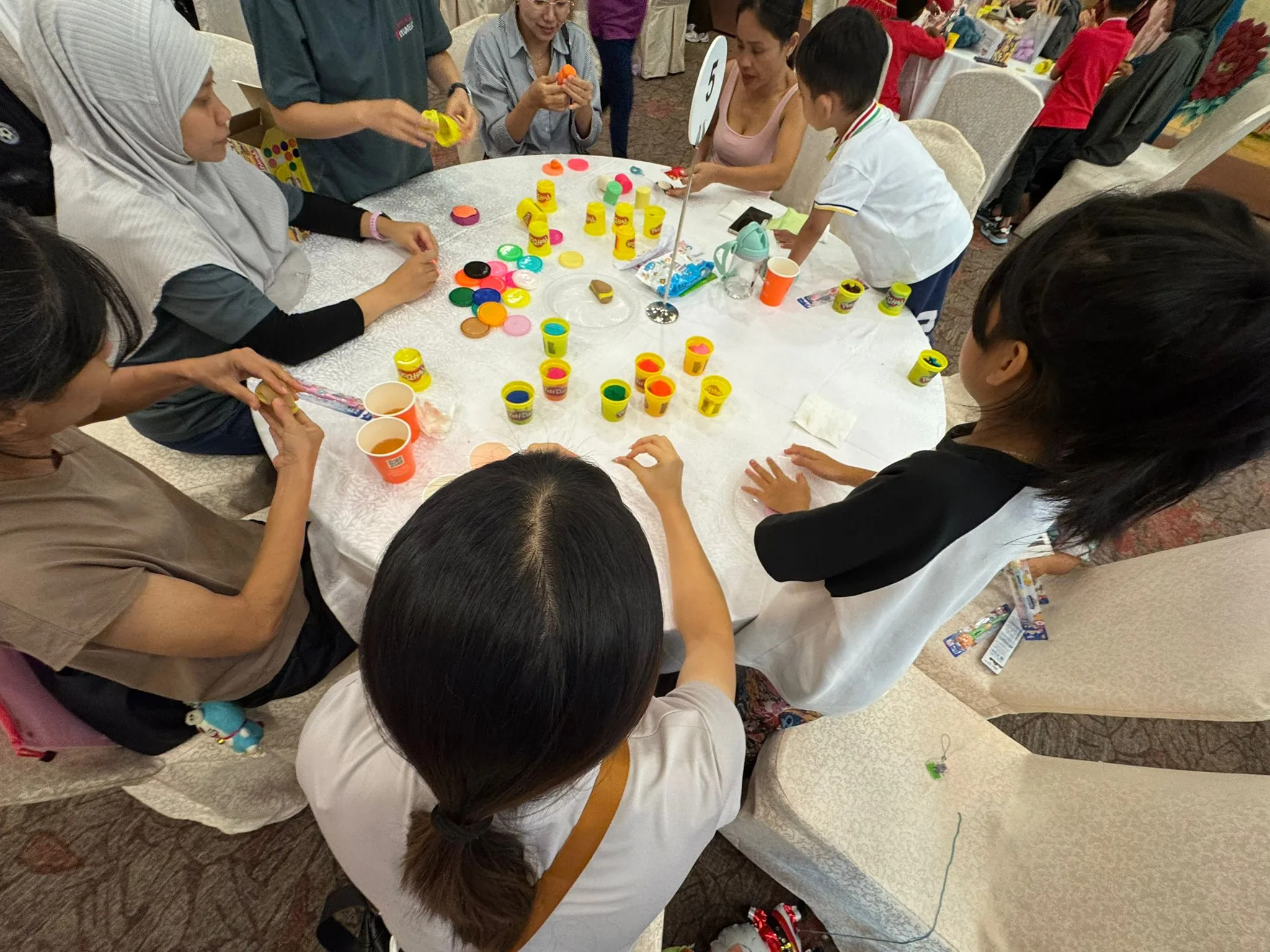 Participants engaged in Playdoh table games