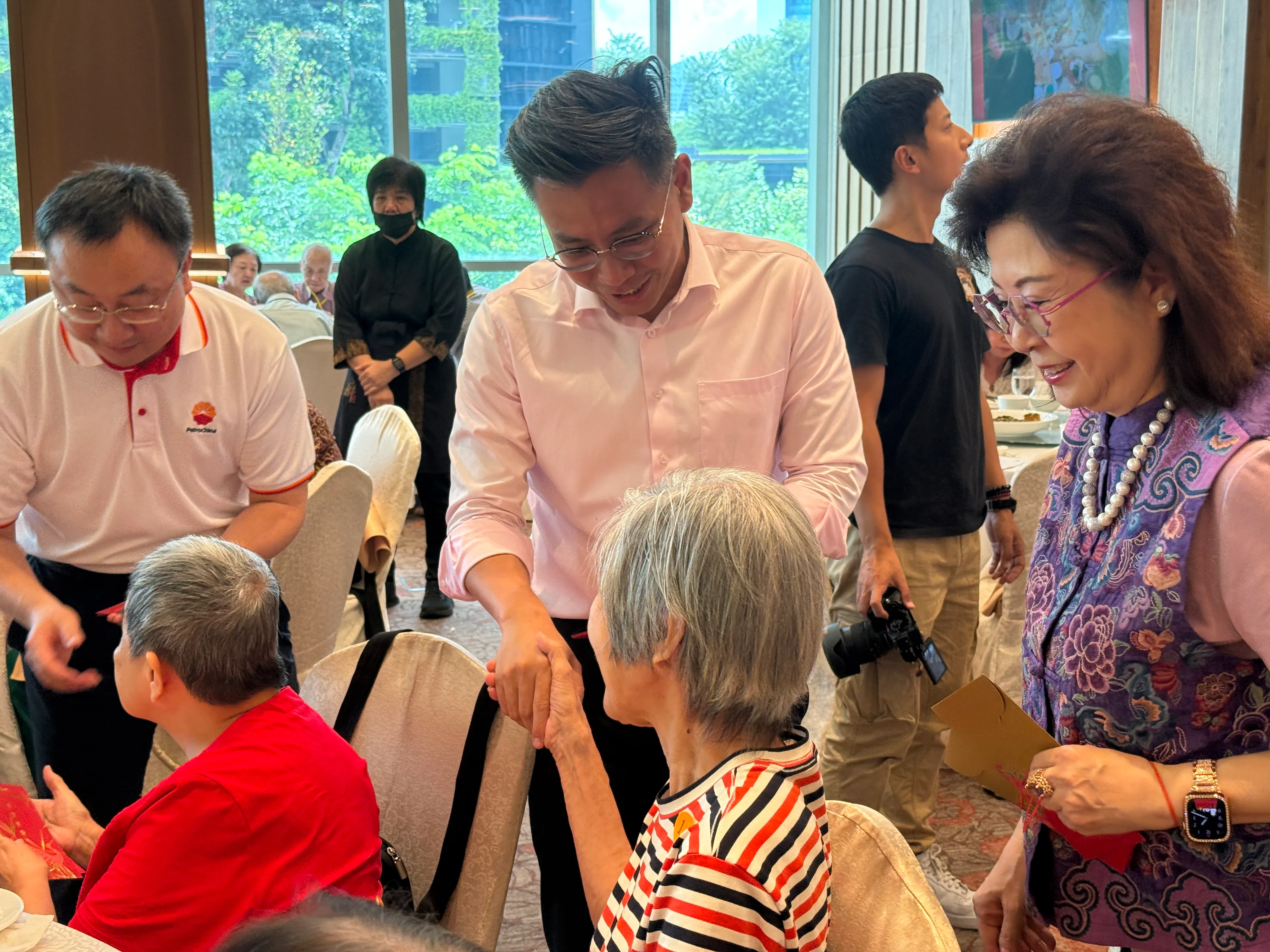 Mr Ng Shi Xuan distributing ang bao to a senior