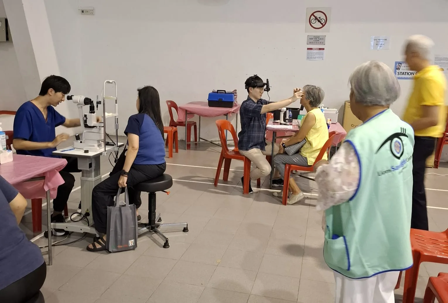 Doctor performing indirect ophthalmoscopy on an elderly participant